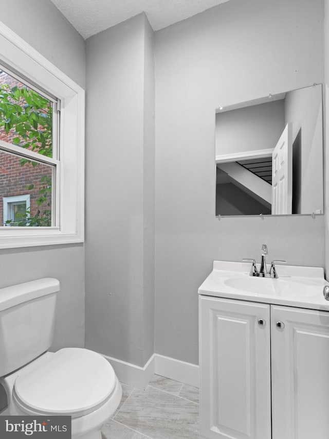 320 E Shedaker St, Philadelphia, PA 19144 - half bathroom featuring toilet, vanity, marble finish floors, baseboards, and a textured ceiling