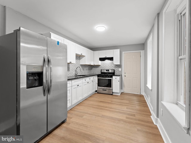 320 E Shedaker St, Philadelphia, PA 19144 - kitchen featuring stainless steel appliances, under cabinet range hood, dark countertops, white cabinetry, and light wood-type flooring