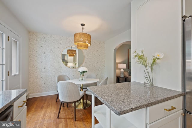 1312 Michigan Ave, Alexandria, VA 22314 - dining space with arched walkways, wallpapered walls, wood finished floors, and baseboards