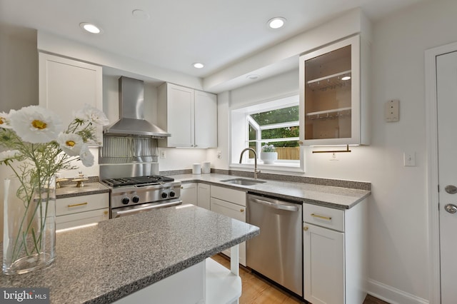 1312 Michigan Ave, Alexandria, VA 22314 - kitchen featuring appliances with stainless steel finishes, wall chimney exhaust hood, a sink, white cabinetry, and glass insert cabinets