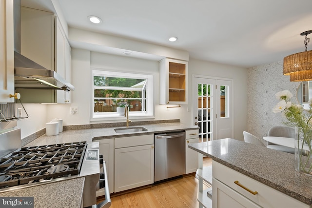 1312 Michigan Ave, Alexandria, VA 22314 - kitchen featuring appliances with stainless steel finishes, wall chimney range hood, a sink, dark stone counters, and pendant lighting