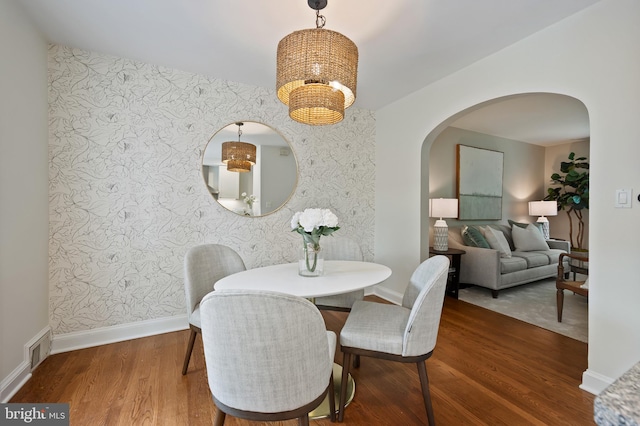 1312 Michigan Ave, Alexandria, VA 22314 - dining room with arched walkways, wallpapered walls, a chandelier, wood finished floors, and baseboards