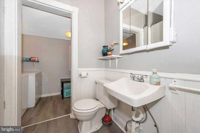 28 N Altamont Ave, Thurmont, MD 21788 - bathroom featuring independent washer and dryer, wainscoting, toilet, and wood finished floors