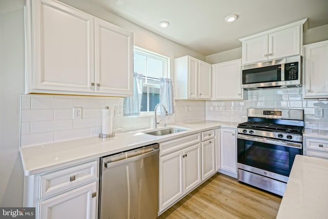 25083 Aspen Cir, Millsboro, DE 19966 - kitchen featuring stainless steel appliances, a sink, light countertops, white cabinets, and backsplash