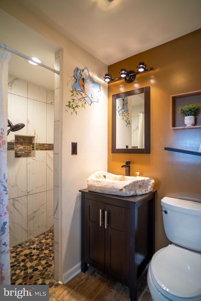 1211 Birch Ave, Baltimore, MD 21227 - full bath with vanity, a tile shower, wood finished floors, toilet, and baseboards