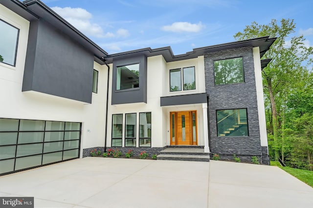 1434 Waggaman Cir, Mclean, VA 22101 - contemporary home with stone siding, stucco siding, driveway, and an attached garage