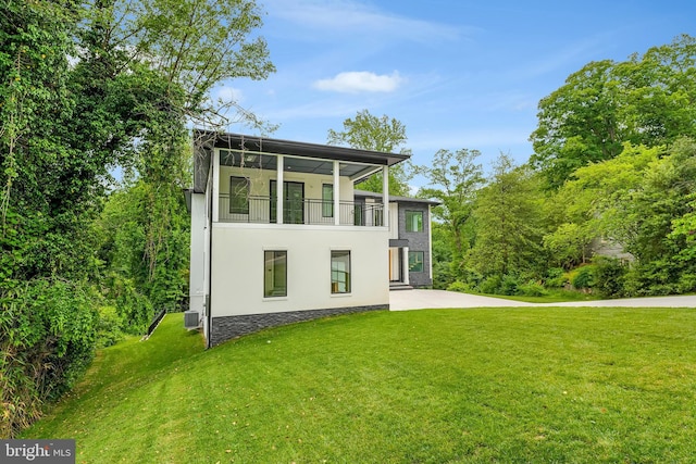 1434 Waggaman Cir, Mclean, VA 22101 - view of front facade with a front yard, stucco siding, a balcony, and a patio area