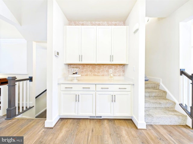 4737 Earl Flanagan Way, Alexandria, VA 22309 - bar area with decorative backsplash, light wood-style floors, baseboards, and stairway