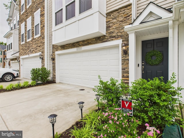 4737 Earl Flanagan Way, Alexandria, VA 22309 - property entrance with stone siding, concrete driveway, and a garage