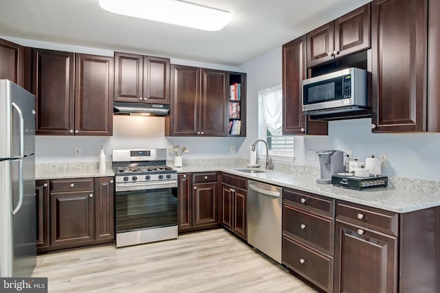 8859 Howland Pl, Bristow, VA 20136 - kitchen with appliances with stainless steel finishes, under cabinet range hood, light wood-type flooring, and dark brown cabinetry