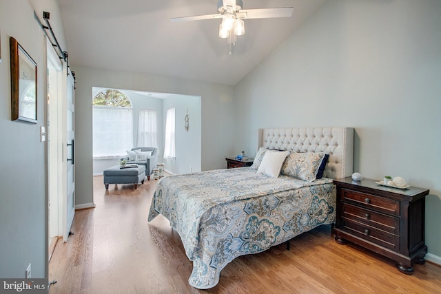 8859 Howland Pl, Bristow, VA 20136 - bedroom featuring light wood finished floors, a barn door, lofted ceiling, and a ceiling fan