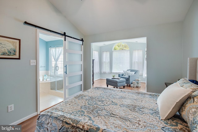 8859 Howland Pl, Bristow, VA 20136 - bedroom with a barn door, wood finished floors, and vaulted ceiling