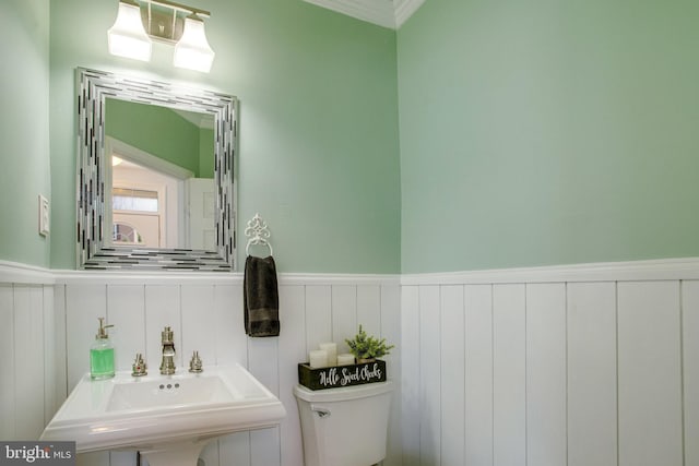 8859 Howland Pl, Bristow, VA 20136 - half bathroom with wainscoting, a decorative wall, and ornamental molding