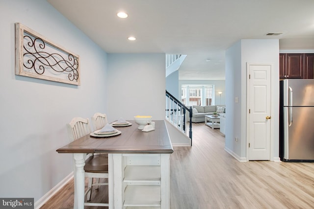 8859 Howland Pl, Bristow, VA 20136 - dining space featuring stairs, light wood-style flooring, and recessed lighting