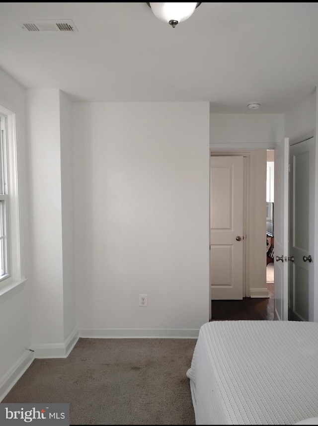 5709 Walther Ave, Baltimore, MD 21206 - unfurnished bedroom featuring baseboards and dark carpet