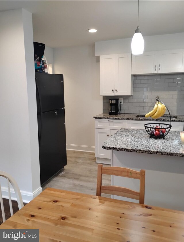 5709 Walther Ave, Baltimore, MD 21206 - kitchen with freestanding refrigerator, baseboards, backsplash, white cabinets, and recessed lighting