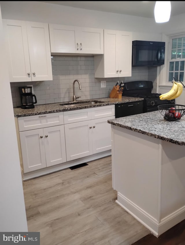 5709 Walther Ave, Baltimore, MD 21206 - kitchen featuring black appliances, a sink, white cabinetry, stone countertops, and decorative backsplash