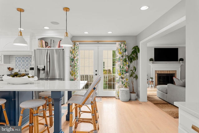 725 Cornerstone Ln, Bryn Mawr, PA 19010 - kitchen with stainless steel fridge with ice dispenser, light countertops, decorative backsplash, a breakfast bar, and hanging light fixtures