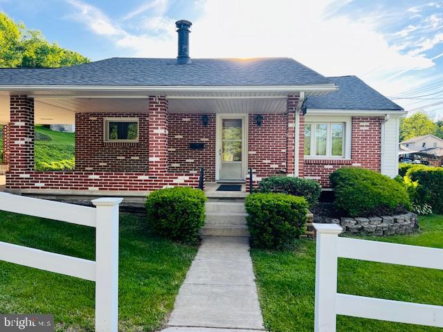 3600 Oak Ave, Altoona, PA 16601 - bungalow-style home with brick siding, a front lawn, roof with shingles, and a porch