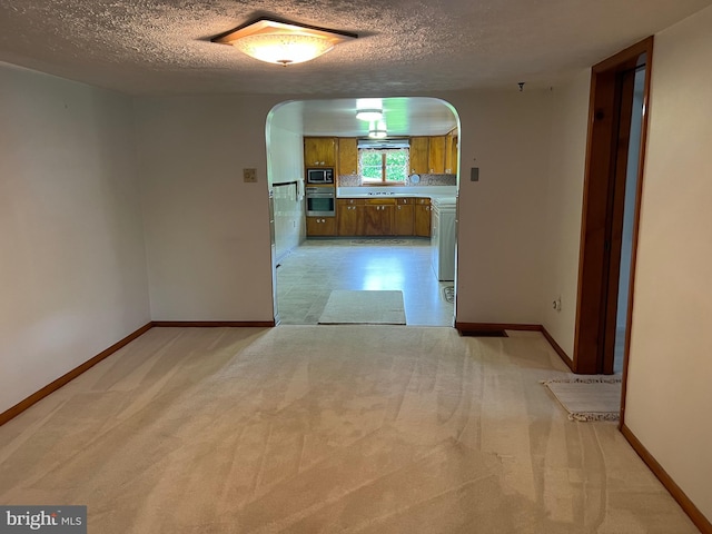 3600 Oak Ave, Altoona, PA 16601 - empty room featuring arched walkways, a textured ceiling, baseboards, and light colored carpet