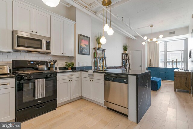 1300 N St NW Unit 817, Washington, DC 20005 - kitchen with stainless steel appliances, dark countertops, light wood-style floors, and a sink