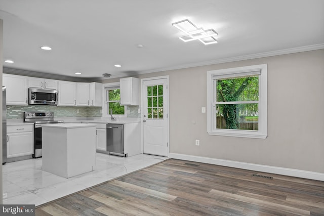 5908 Michael Rd, Waldorf, MD 20601 - kitchen featuring stainless steel appliances, crown molding, white cabinetry, healthy amount of natural light, and decorative backsplash
