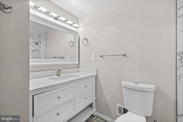 5908 Michael Rd, Waldorf, MD 20601 - bathroom with vanity, marble look tiles, toilet, and baseboards