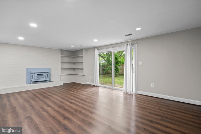 5908 Michael Rd, Waldorf, MD 20601 - unfurnished living room with dark wood-type flooring, baseboards, a wood stove, recessed lighting, and built in shelves