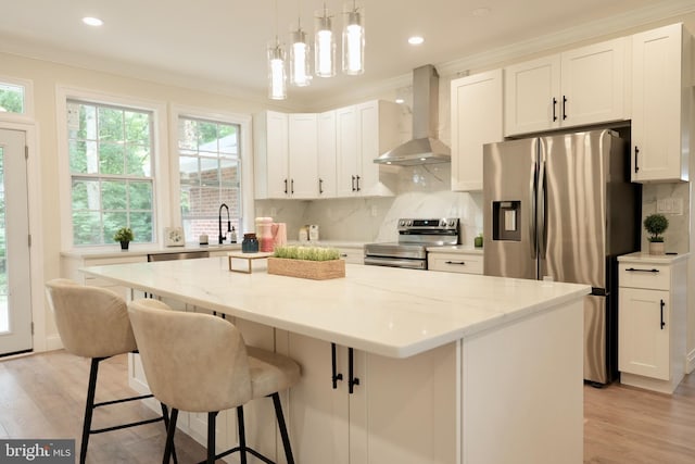 5503 Blacksburg Rd, Springfield, VA 22151 - kitchen featuring wall chimney range hood, stainless steel appliances, a kitchen island, backsplash, and light wood finished floors