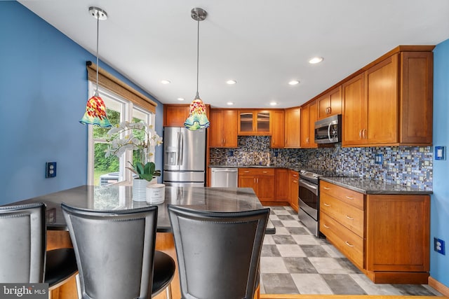 1918 Michael Rd, Waldorf, MD 20601 - kitchen with stainless steel appliances, tasteful backsplash, a sink, brown cabinets, and pendant lighting
