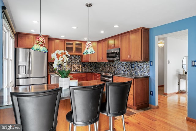1918 Michael Rd, Waldorf, MD 20601 - kitchen featuring stainless steel appliances, dark countertops, decorative backsplash, light wood finished floors, and brown cabinets