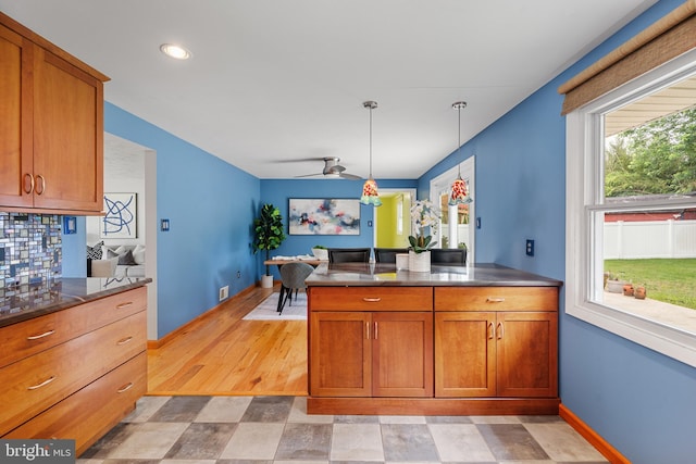 1918 Michael Rd, Waldorf, MD 20601 - kitchen with brown cabinetry, decorative light fixtures, a peninsula, baseboards, and dark countertops