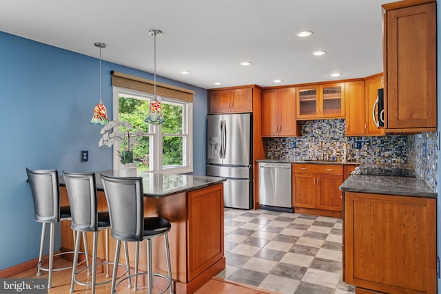 1918 Michael Rd, Waldorf, MD 20601 - kitchen with stainless steel appliances, brown cabinetry, dark countertops, tasteful backsplash, and a breakfast bar area