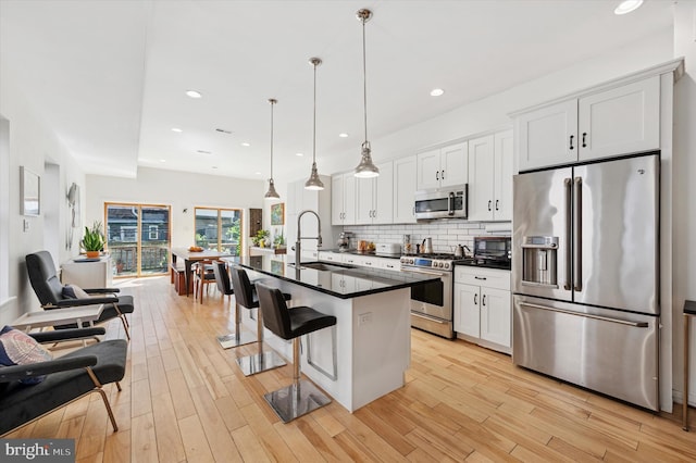 810 S 49th St, Philadelphia, PA 19143 - kitchen featuring appliances with stainless steel finishes, a sink, dark countertops, white cabinets, and decorative backsplash