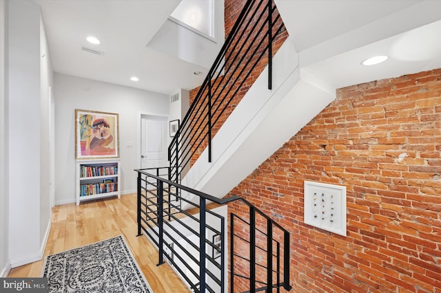 810 S 49th St, Philadelphia, PA 19143 - staircase featuring baseboards, brick wall, recessed lighting, and wood finished floors