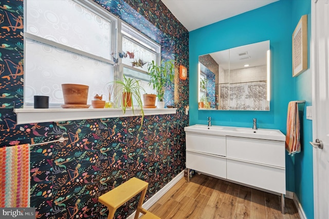 810 S 49th St, Philadelphia, PA 19143 - bathroom with wood finished floors, double vanity, baseboards, and wallpapered walls