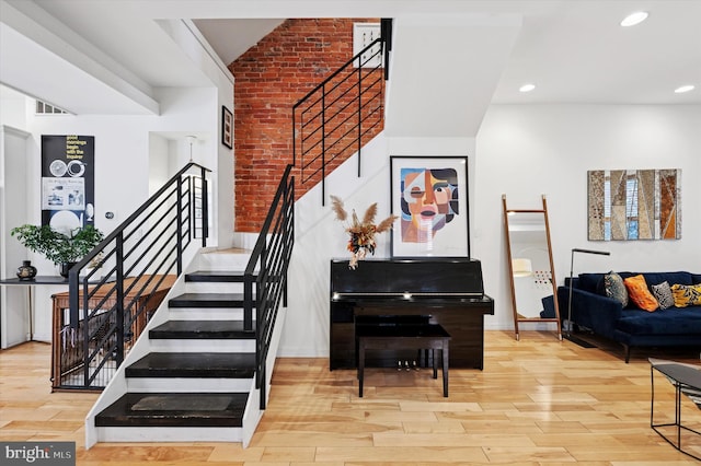 810 S 49th St, Philadelphia, PA 19143 - stairs with wood finished floors, brick wall, and recessed lighting