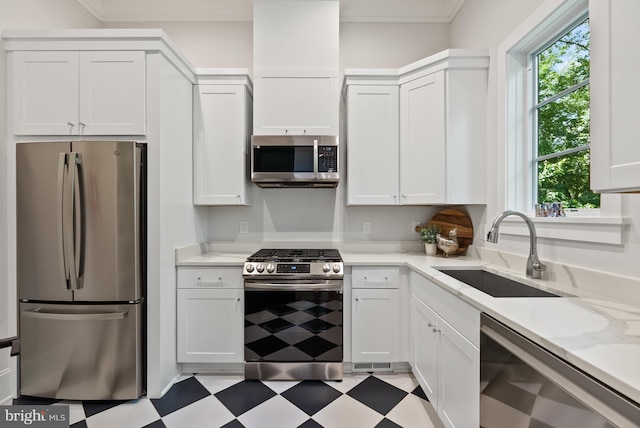 825 Whann Ave, Mclean, VA 22101 - kitchen featuring appliances with stainless steel finishes, light floors, a sink, white cabinetry, and ornamental molding
