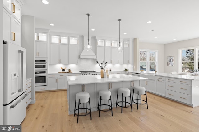 1749 Beulah Rd, Vienna, VA 22182 - kitchen featuring white appliances, a sink, premium range hood, a kitchen island, and a kitchen bar