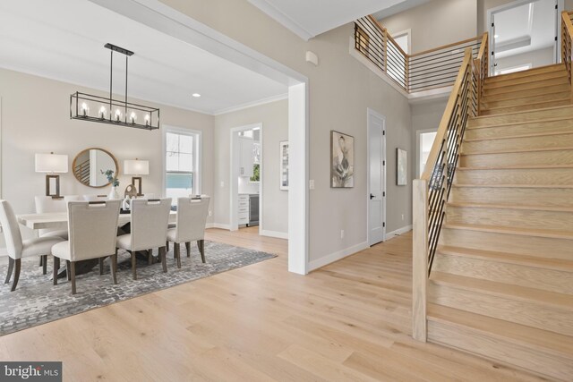1749 Beulah Rd, Vienna, VA 22182 - dining area with stairway, a chandelier, crown molding, baseboards, and light wood-type flooring
