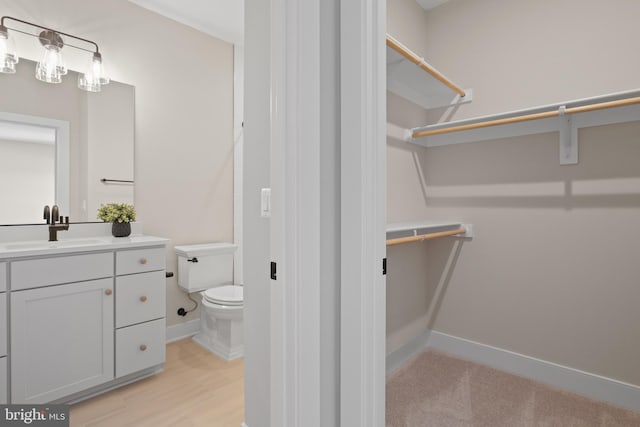 1749 Beulah Rd, Vienna, VA 22182 - half bathroom with toilet, vanity, baseboards, and wood finished floors