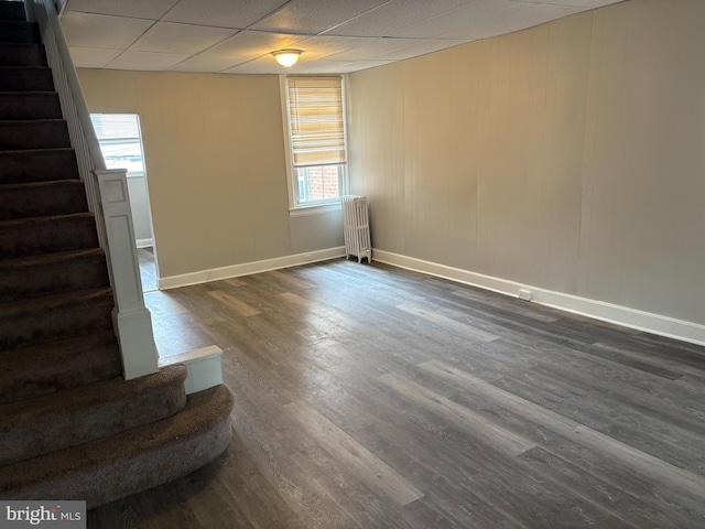 4728 Marple St, Philadelphia, PA 19136 - empty room featuring stairs, radiator, dark wood-style flooring, baseboards, and a paneled ceiling
