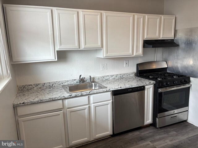 4728 Marple St, Philadelphia, PA 19136 - kitchen with stainless steel appliances, under cabinet range hood, a sink, white cabinets, and dark wood-style flooring