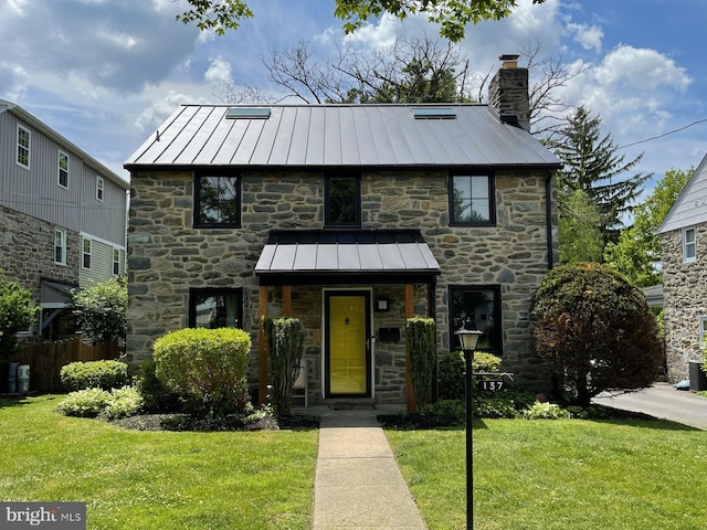 137 Sutton Rd, Ardmore, PA 19003 - view of front facade featuring a standing seam roof, stone siding, a chimney, and metal roof