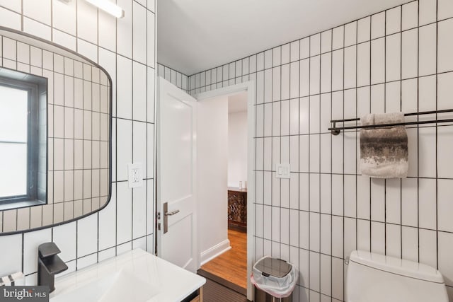 137 Sutton Rd, Ardmore, PA 19003 - bathroom with tile walls, toilet, vanity, healthy amount of natural light, and wood finished floors