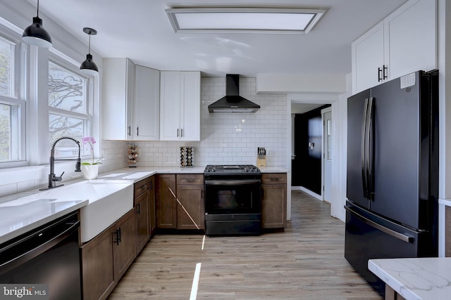 3530 Baker Rd, Westminster, MD 21157 - kitchen with black appliances, wall chimney range hood, a sink, tasteful backsplash, and light wood-type flooring