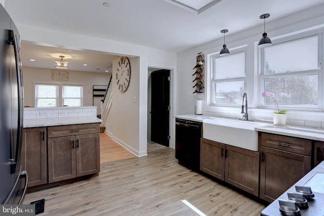 3530 Baker Rd, Westminster, MD 21157 - kitchen featuring freestanding refrigerator, black dishwasher, a sink, light wood-style flooring, and decorative light fixtures