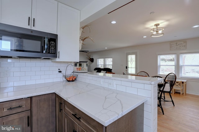 3530 Baker Rd, Westminster, MD 21157 - kitchen featuring stainless steel microwave, a peninsula, backsplash, light wood-type flooring, and recessed lighting