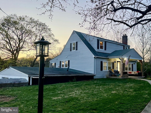 3530 Baker Rd, Westminster, MD 21157 - back of house at dusk with a chimney, an outdoor hangout area, and a lawn