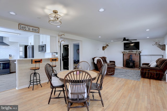 3530 Baker Rd, Westminster, MD 21157 - dining room with light wood-style flooring, ceiling fan, recessed lighting, baseboards, and a wood stove